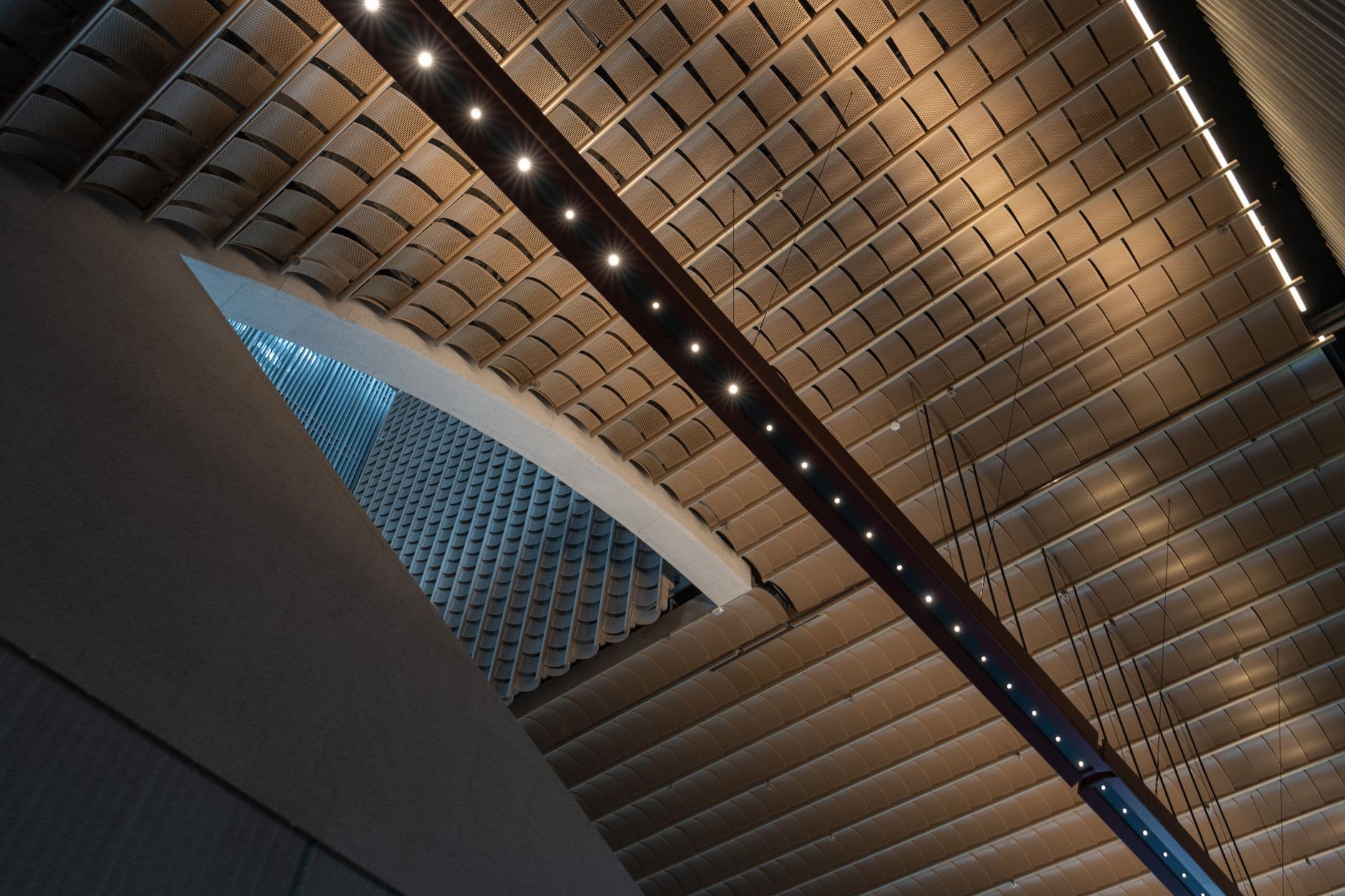 A line of small lights set into a panelled ceiling, seen from below.